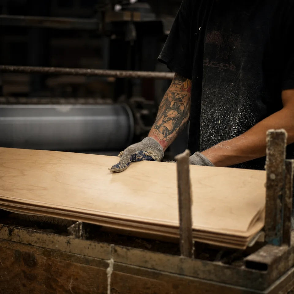 Factory worker hand-selecting Canadian maple veneer sheets